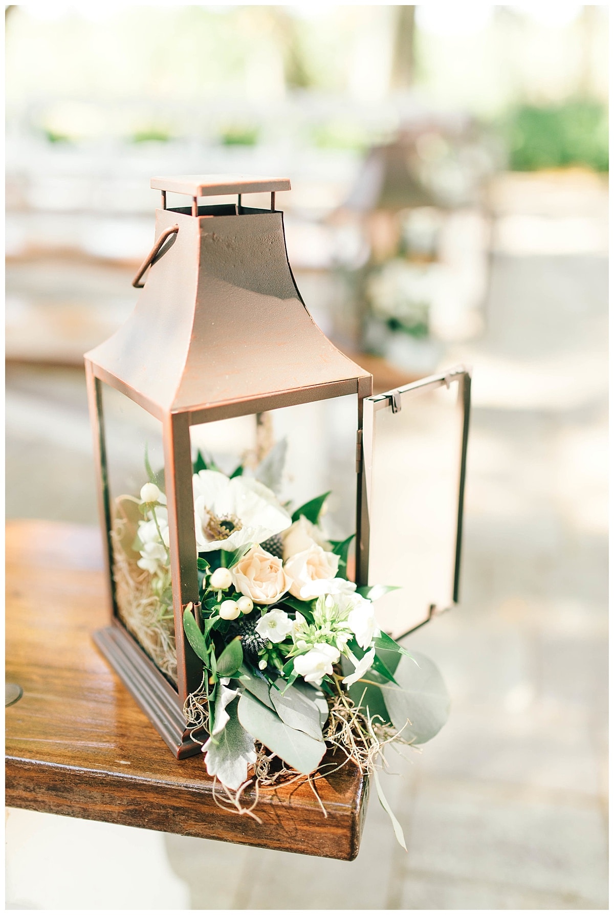 Rustic bronze lanterns filled with up the creek farm florals 