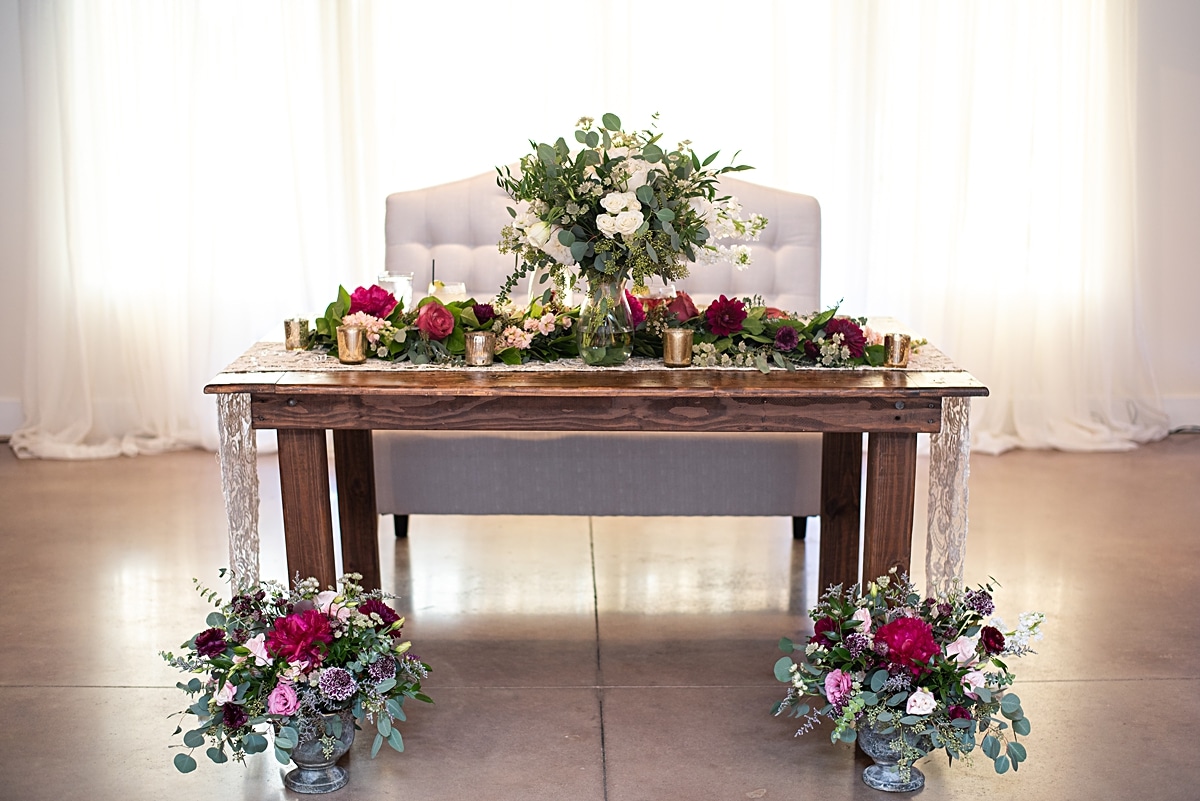 Rustic sweetheart table with lace runner, rustic compotes and blush toned florals and greenery