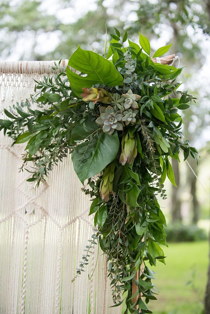 earthy boho chic wedding arbor with greenery and succulent accents