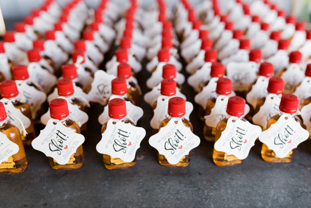Tiny whiskey bottle wedding favors at rustic wedding at Up The Creek Farms