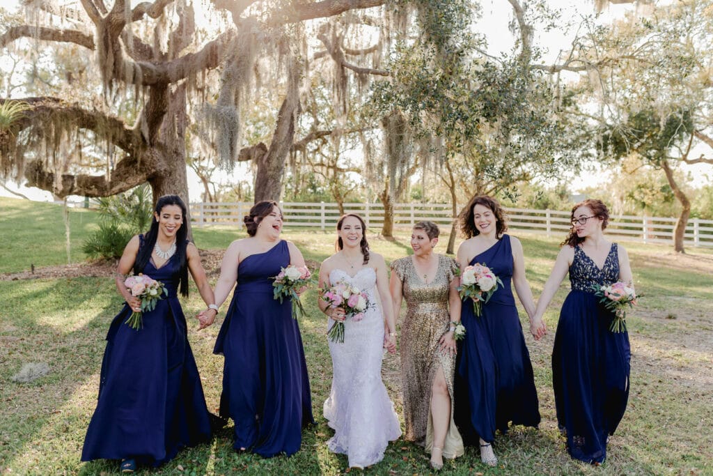 Eclectic bridal party with navy bridesmaid dresses and gold maid of honor gown 