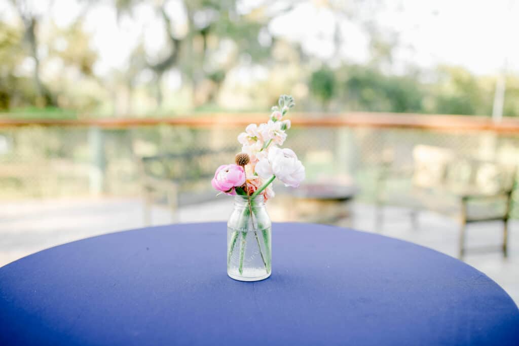 Delicate cocktail table blooms in a sweet rustic jar vase