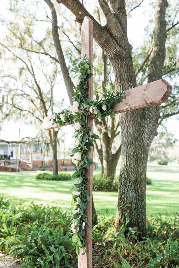 crystal and crates wooden ceremony cross with seeded eucalyptus greenery florals
