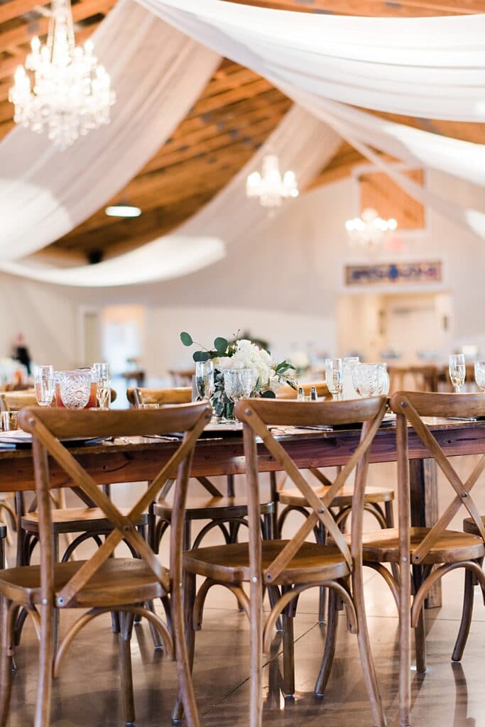 rustic farm tables and french country chairs at this boathouse reception in brevard county