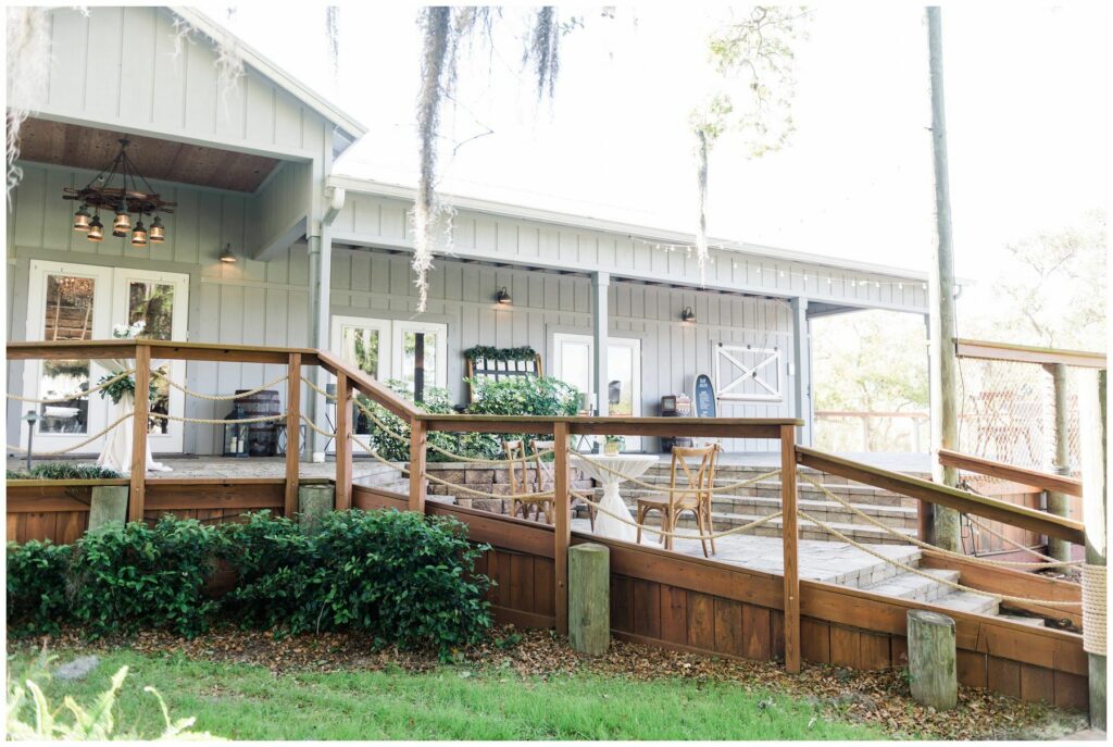 Rustic front porch of boathouse opening into oak lawn at up the creek farms