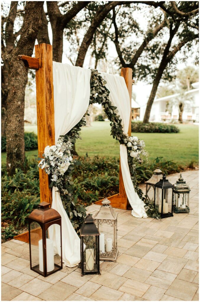 outdoor ceremony with pipe and drape arbor, rustic lanterns and bohemian florals