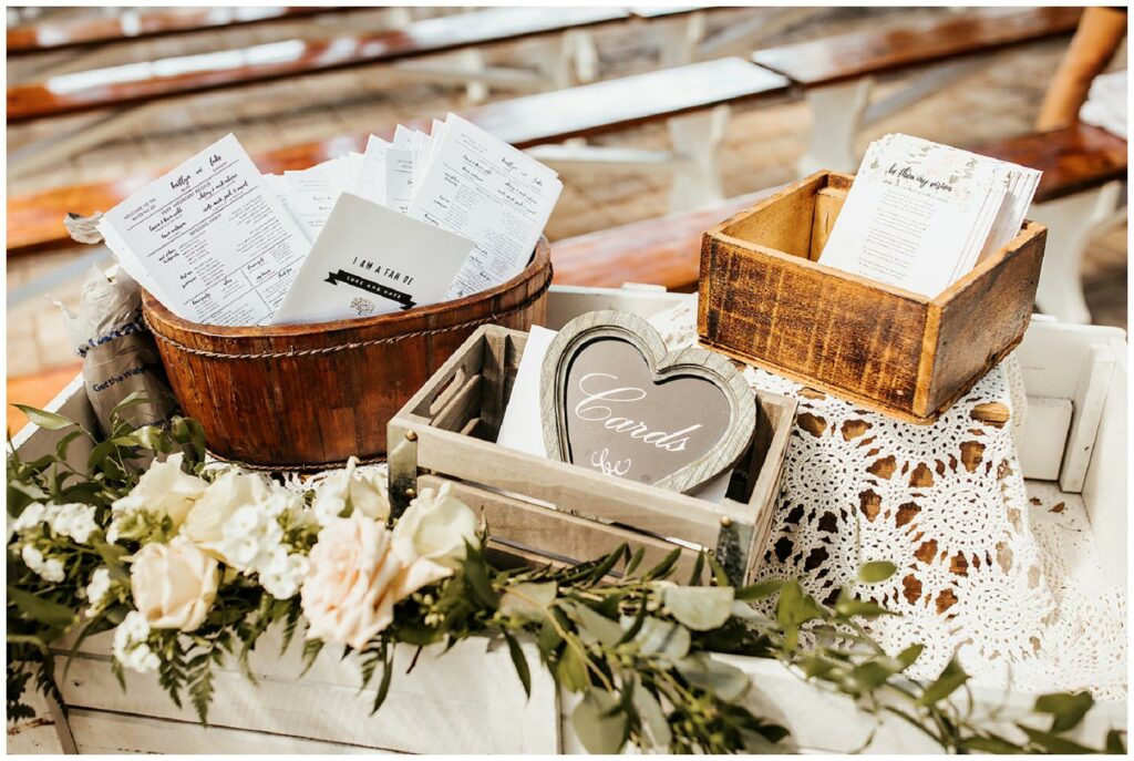 Rustic card display cart with vintage wooden boxes and flower cart