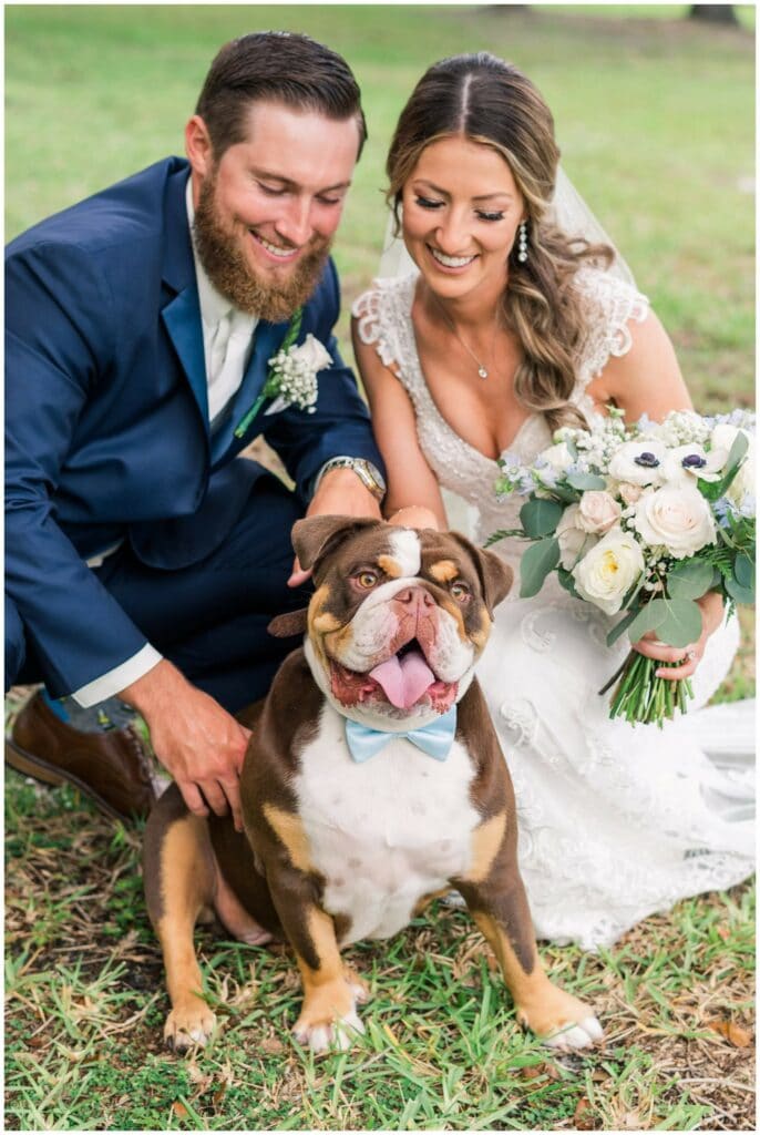 First look photo with bride and groom with their bulldog wearing a bow tie