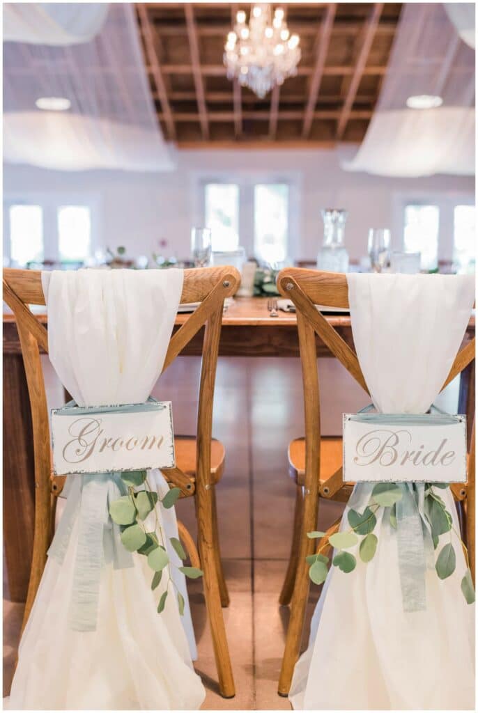 rustic bride and groom chair signs featuring greenery 