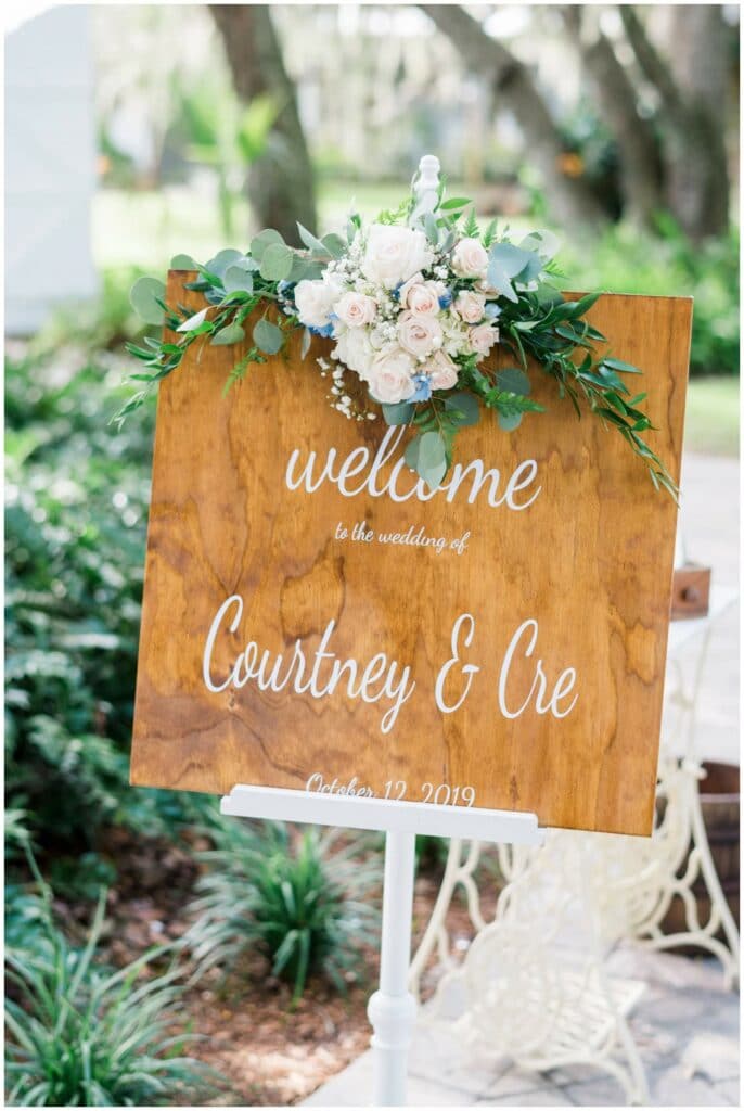 Crystal and crates wooden welcome sign with white calligraphy