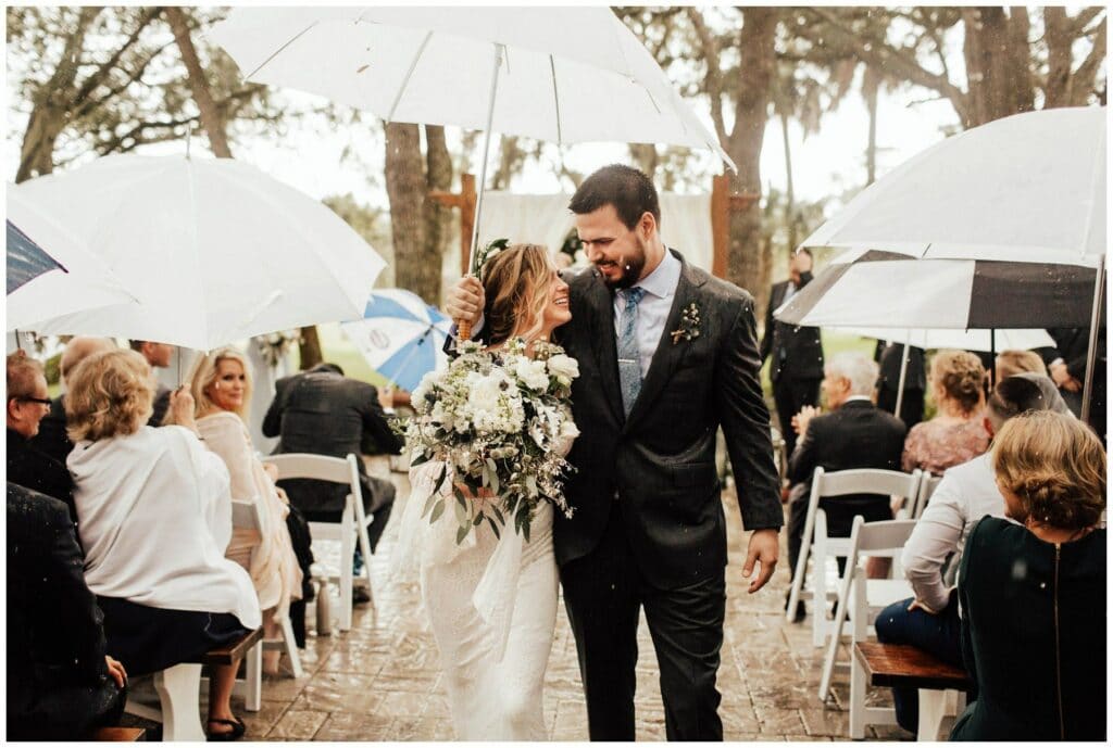 Rainy outdoor ceremony at up the creek farms with umbrellas 