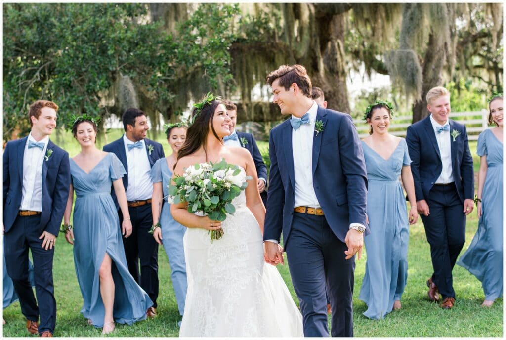 navy blue groomsmen with periwinkle blue bridesmaids and greenery crowns