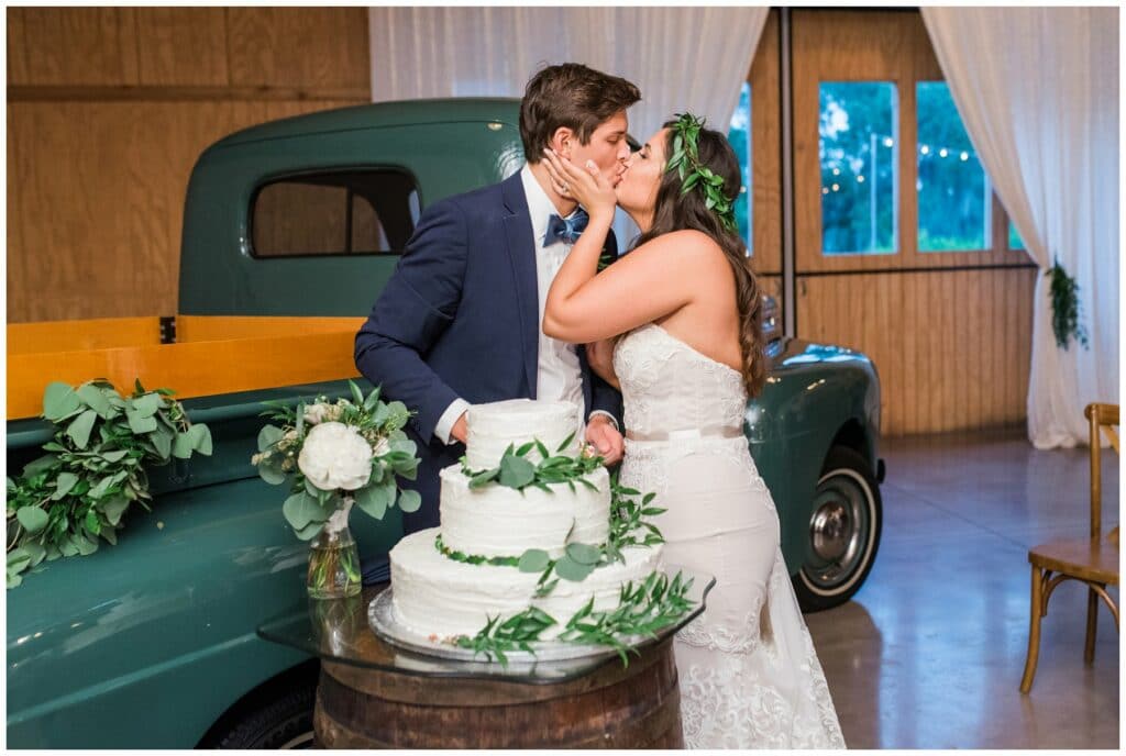 antique 1948 ford pickup truck wedding prop featuring rustic greenery decor and a classic textured white buttercream cake with greenery accents