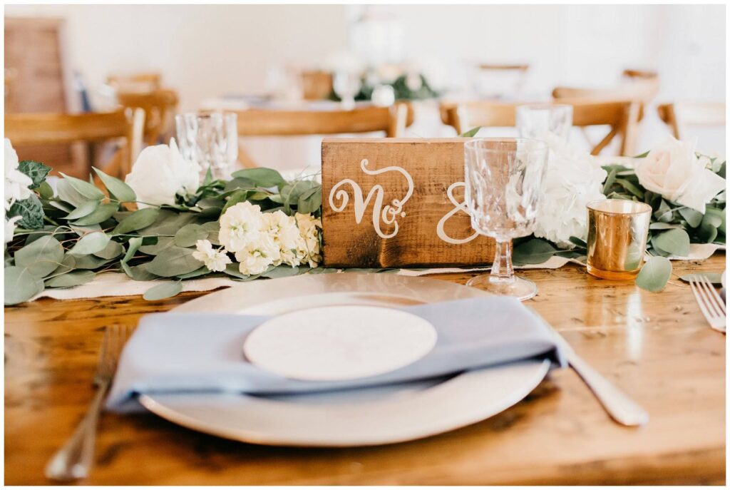 whimsical southern wedding reception tablescapes with wooden table numbers and pale blue napkins