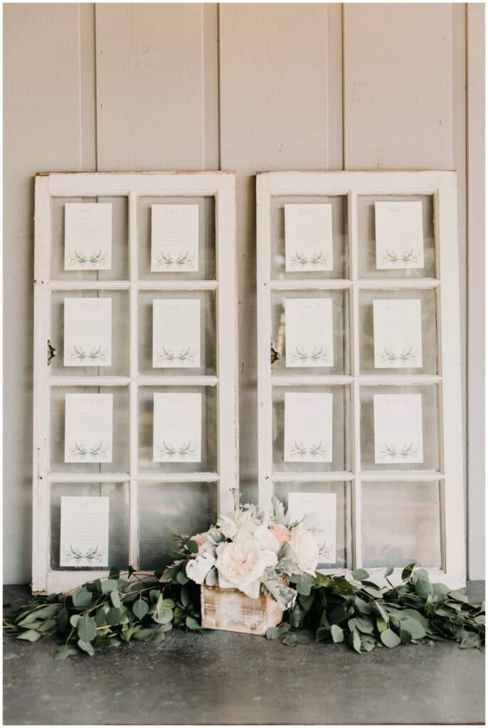 White distressed windowpane seating chart display with up the creek farm florals
