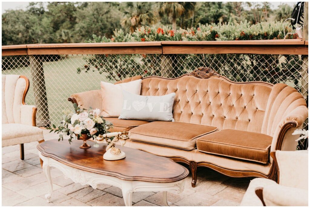 Crystal and Crates Brevard County furniture rentals featuring a vintage brown velvet sofa and mahogany coffee table. 