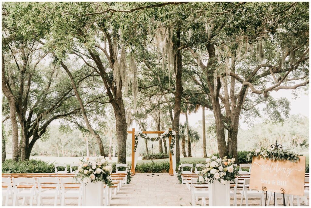 Elegant southern outdoor wedding  ceremony with white pedestals and wooden arbor