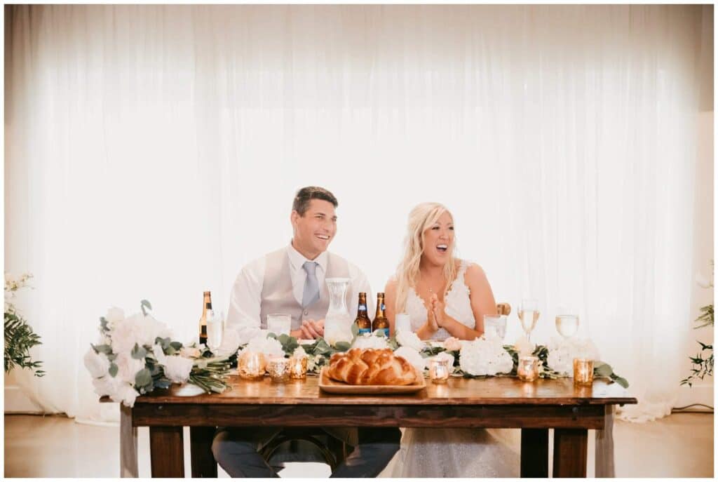 romantic and rustic sweetheart table with challah bread and gold votives at up the creek farms