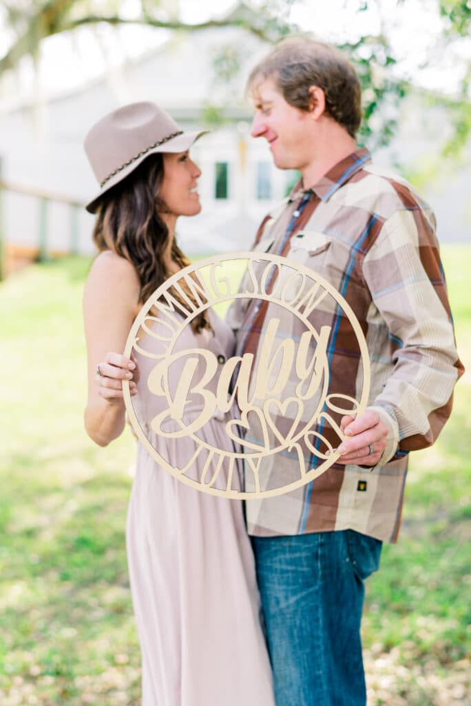 Maternity shoot at Up The Creek Farms with baby news sign 