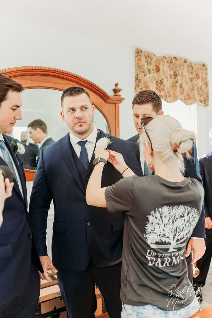 up the creek farms wedding coordinator Briana hoover fixing a boutonniere 