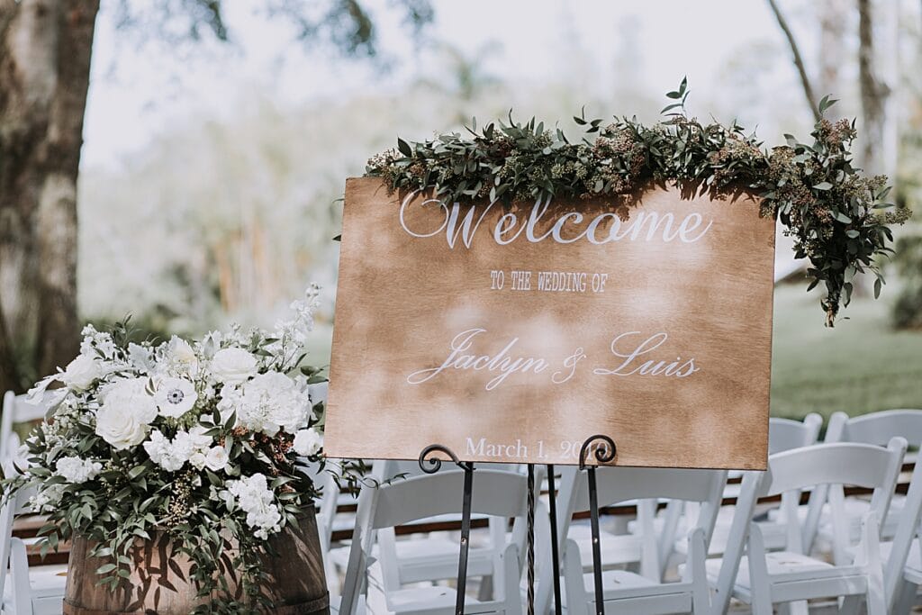 wooden wedding welcome sign with earthy greenery 
