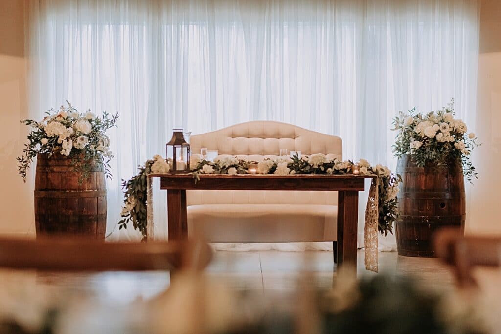 romantic sweetheart table with whiskey barrels and lanterns at up the creek farms