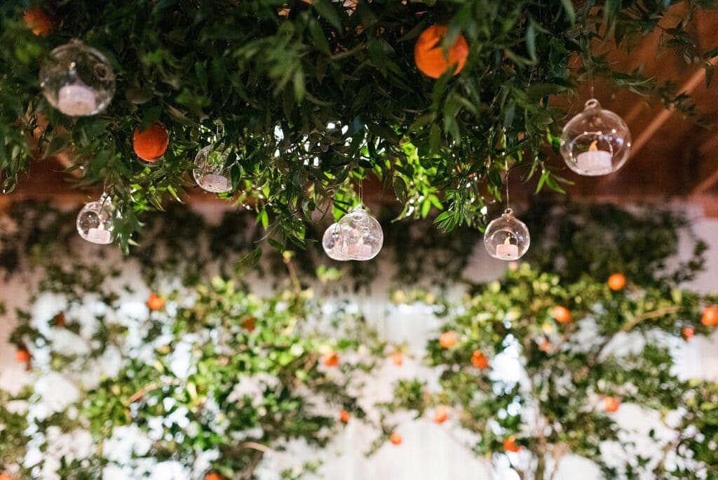 Hanging greenery with glass candle orbs and orange trees