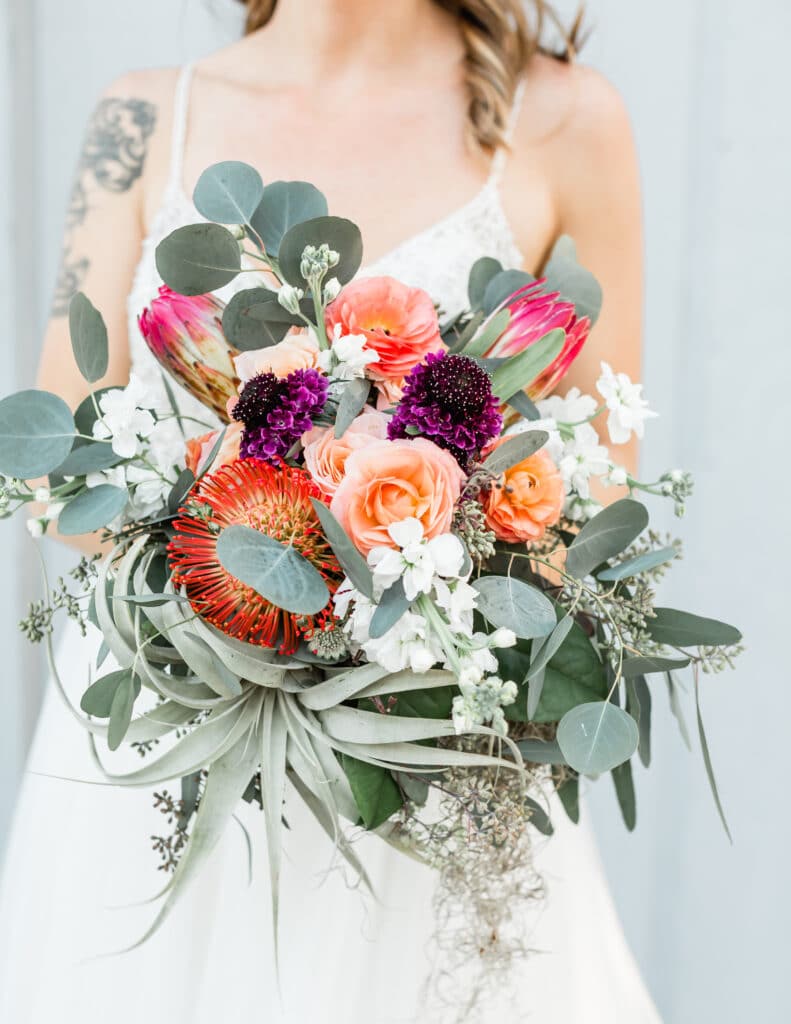 Bridal bouquet of rustic flowers like Ranunculus and Protea