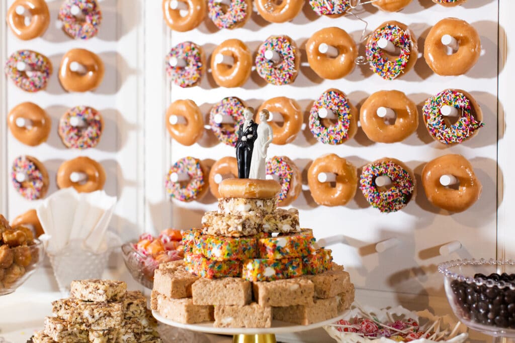 Custom made donut wall dessert display with a 1940s vintage cake topper and rice krispie treat cake