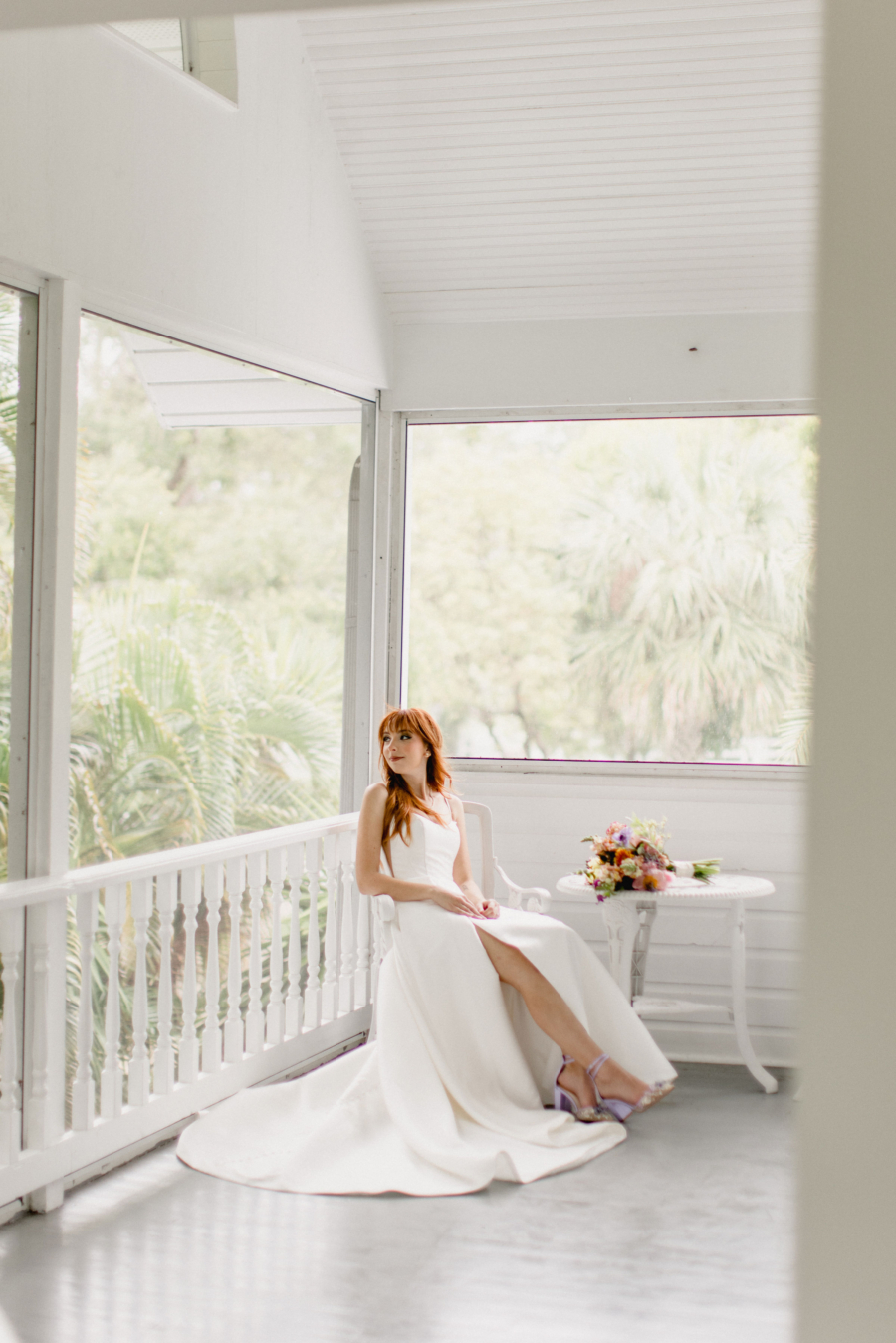 Bride posed on the white-washed porch at a historic farmhouse wedding venue in Florida.