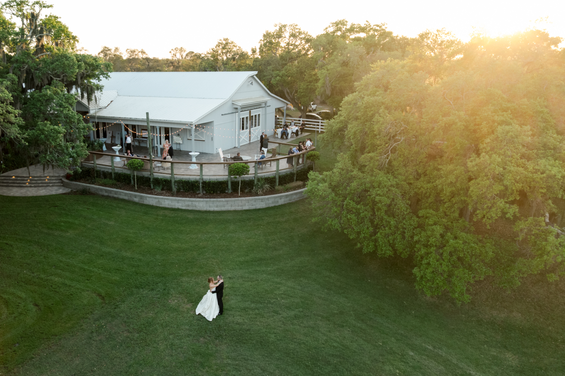 Wedding couple dancing on the lawn at sunset